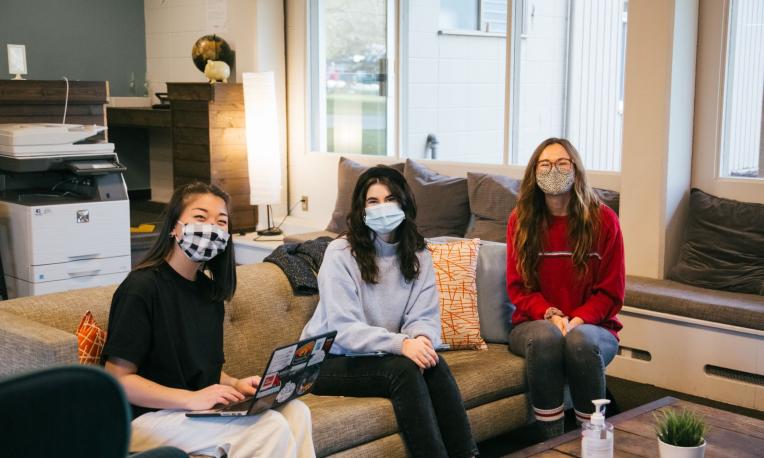 students sitting on a sofa and smiling
