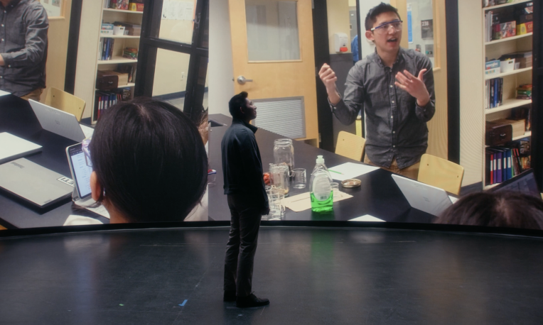 Sean Hui standing in front of screen