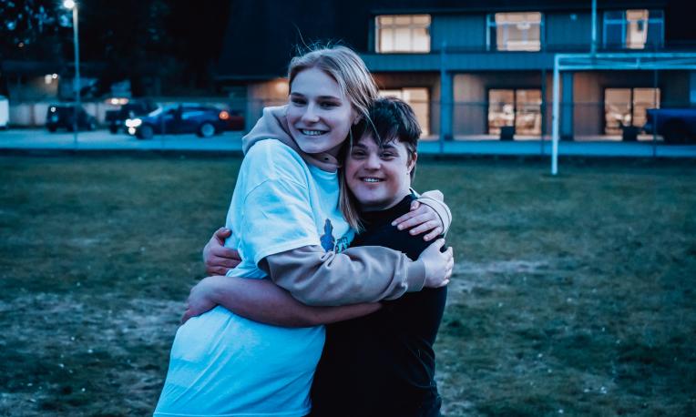 Two people hugging and smiling at the camera