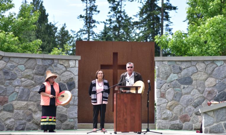 A group of indigenous people stand at the outdoor chapel.