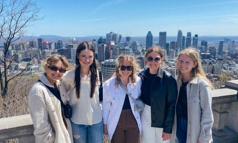 A group of students stand together with a view of the Ottawa skyline in the background.