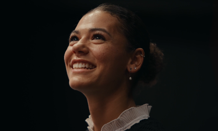 Aliya smiling with a black background