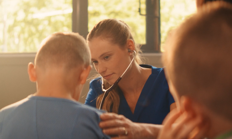 Brianne using a stethoscope to hear someone's heartbeat