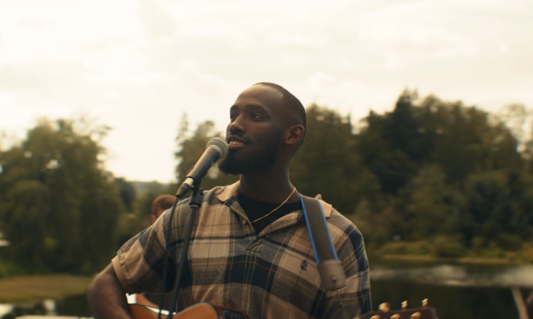 David smiling and playing guitar