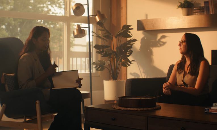 Rebecca counselling someone in a dimly lit room