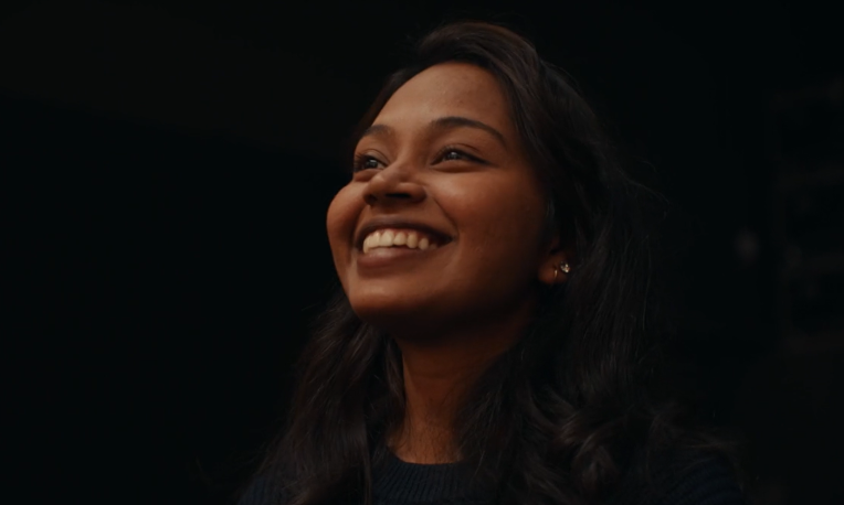 Rebecca smiling with a black background