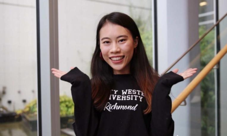 A student shrugging with her hands up