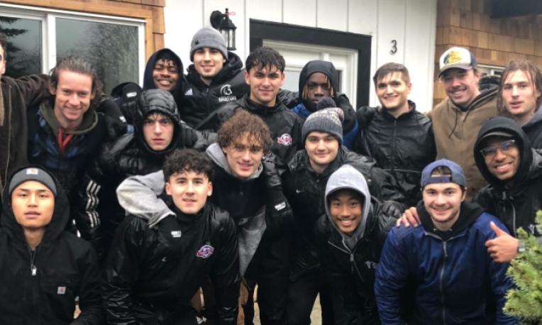 TWU athletes outside in the rain wearing black