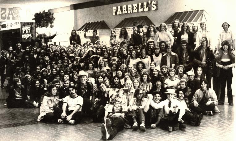 Large group of people gathered in front of a Farrell's restaurant in a vintage photo.