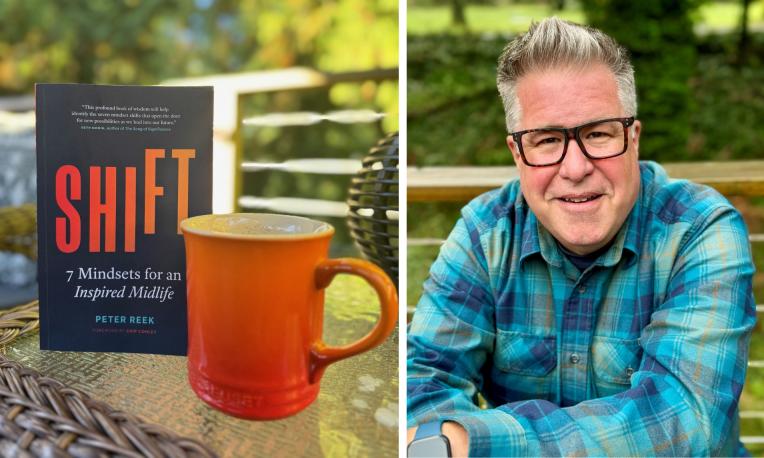 Book and mug and man beside both.