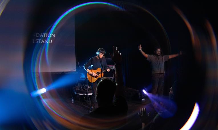 Concert with guitarist and singer under colorful stage lights.