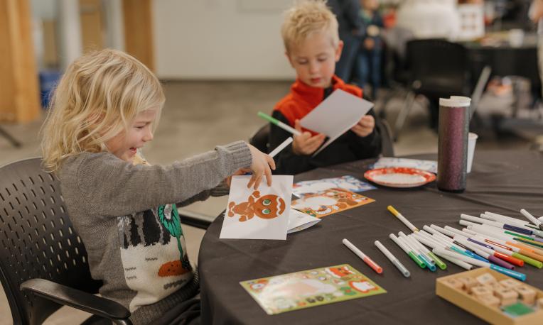 Two young children making Christmas cards.