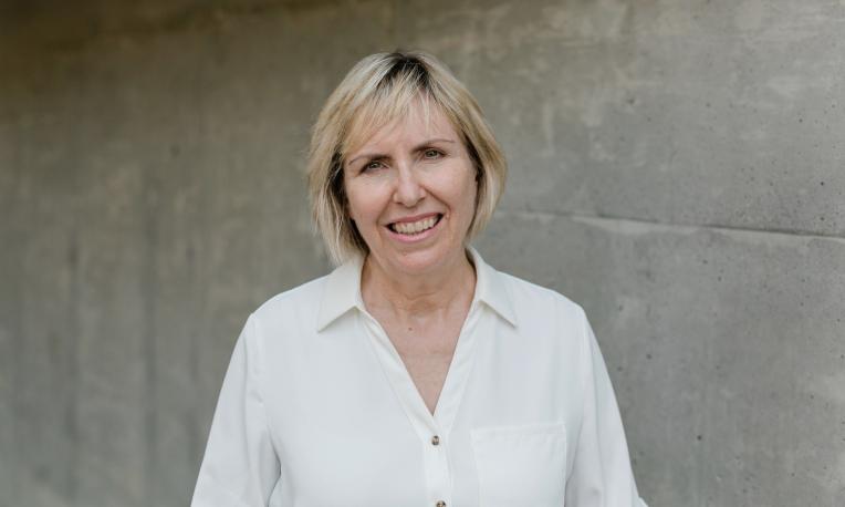 Susan Wendel standing in front of a grey wall