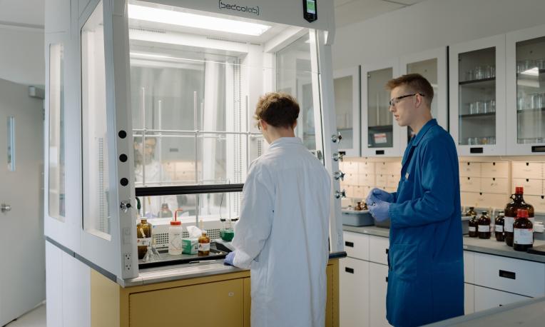 people working in a chemistry lab at TWU under a fume hood