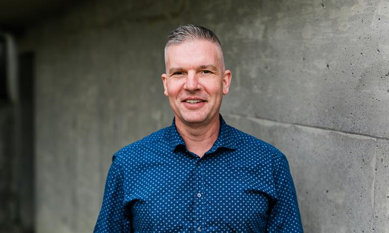 Headshot of Chad Friesen in front of grey wall