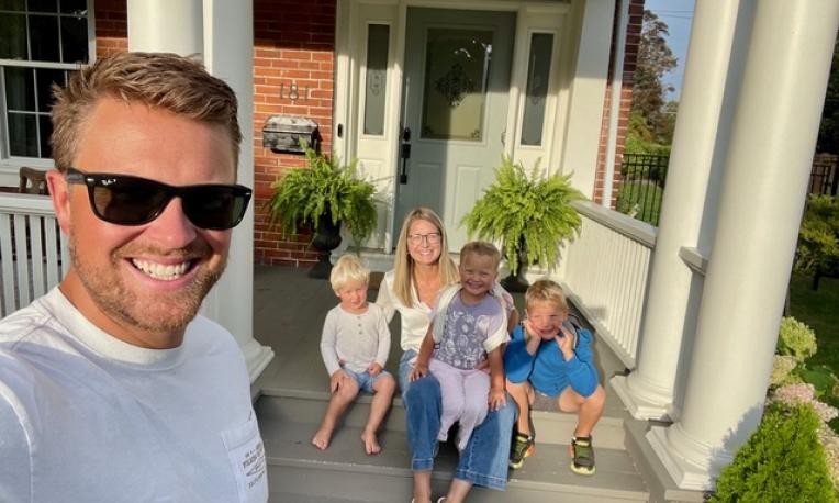 Man with his family on their porch