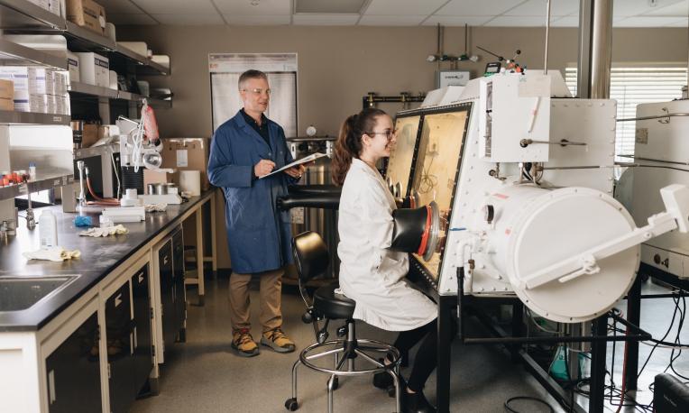 Chad Friesen working with student in lab