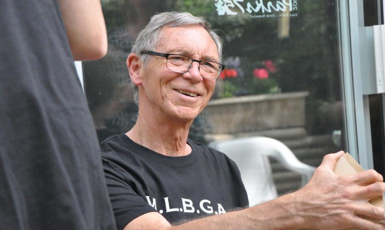 Jack Van Dyke sitting and smiling in front of a glass wall