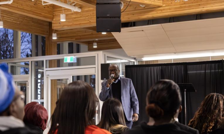 Man speaking to crowd in the foreground