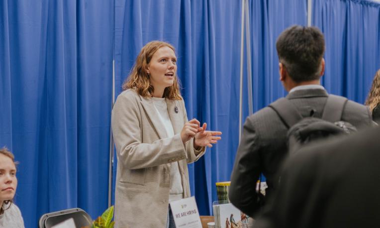 women talking to person at booth