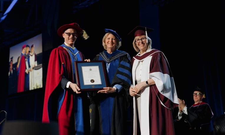 Shirley V. Hoogstra, JD receiving an honorary degree from the President and Provost while in cap and gown