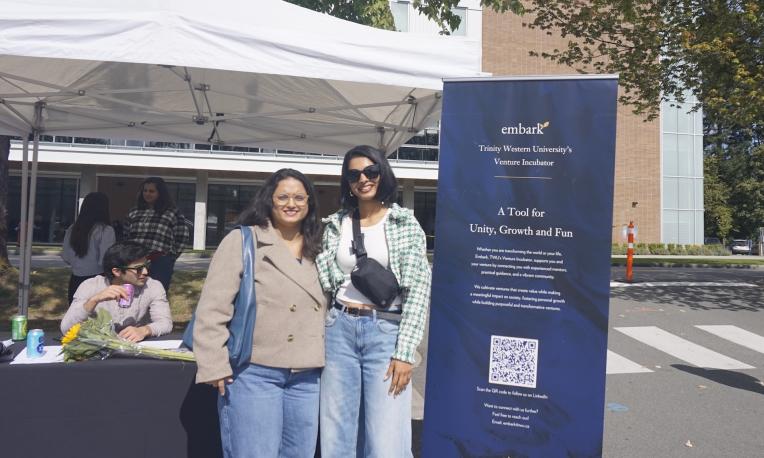 People standing in front of an outdoor booth