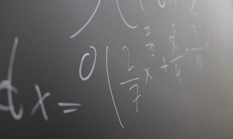Mathematical formulas written on a classroom chalkboard.