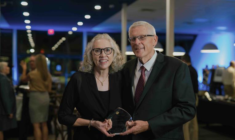 Darwin and Darlis Anderson holding the 2026 Live Faithfully Award at TWU’s Alumni Awards Dinner.