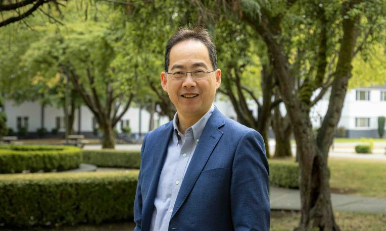 David Pao standing outdoors on the Trinity Western University campus.