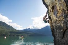 person climbing rocks above water