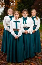 four girls wearing school uniforms with serious expressions on their faces