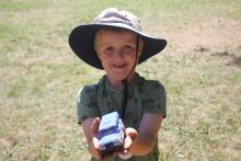 little boy holding toy truck and smiling