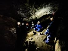 group of people in cave in the dark