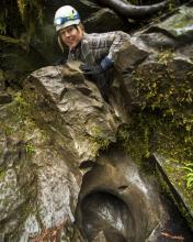 woman climbing over a rock