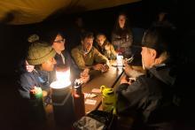 people eating together in a tent at night