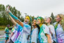 students taking a selfie covered in coloured powder