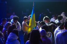 people standing around flag and praying