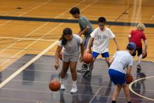 A group of kids dribbling a basketball