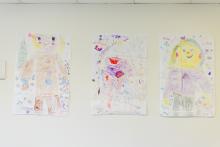 Three photos of people or robots done by children in pencil or crayons