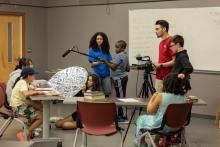 A group of 8 people in the process of recording something