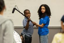 Two people holding a boom pole