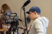 A young boy positioning a camera 