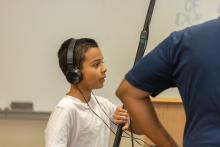 A young boy wearing headphones and holding a microphone