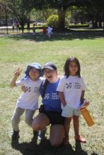 Two young girls posing for a photo with staff.