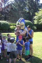 Kids gathering around the university mascot, Sparty.