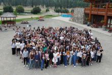 A large group of students and parents posing for the camera from a distant