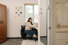 Student working at a desk in a residence room in DeVries Centre