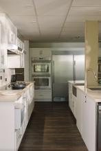 Robson Hall kitchen with white cabinetry and stainless-steel appliances.