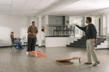 Students playing cornhole in a residence common area.