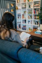 Student reading a book in the lounge area at The Well.
